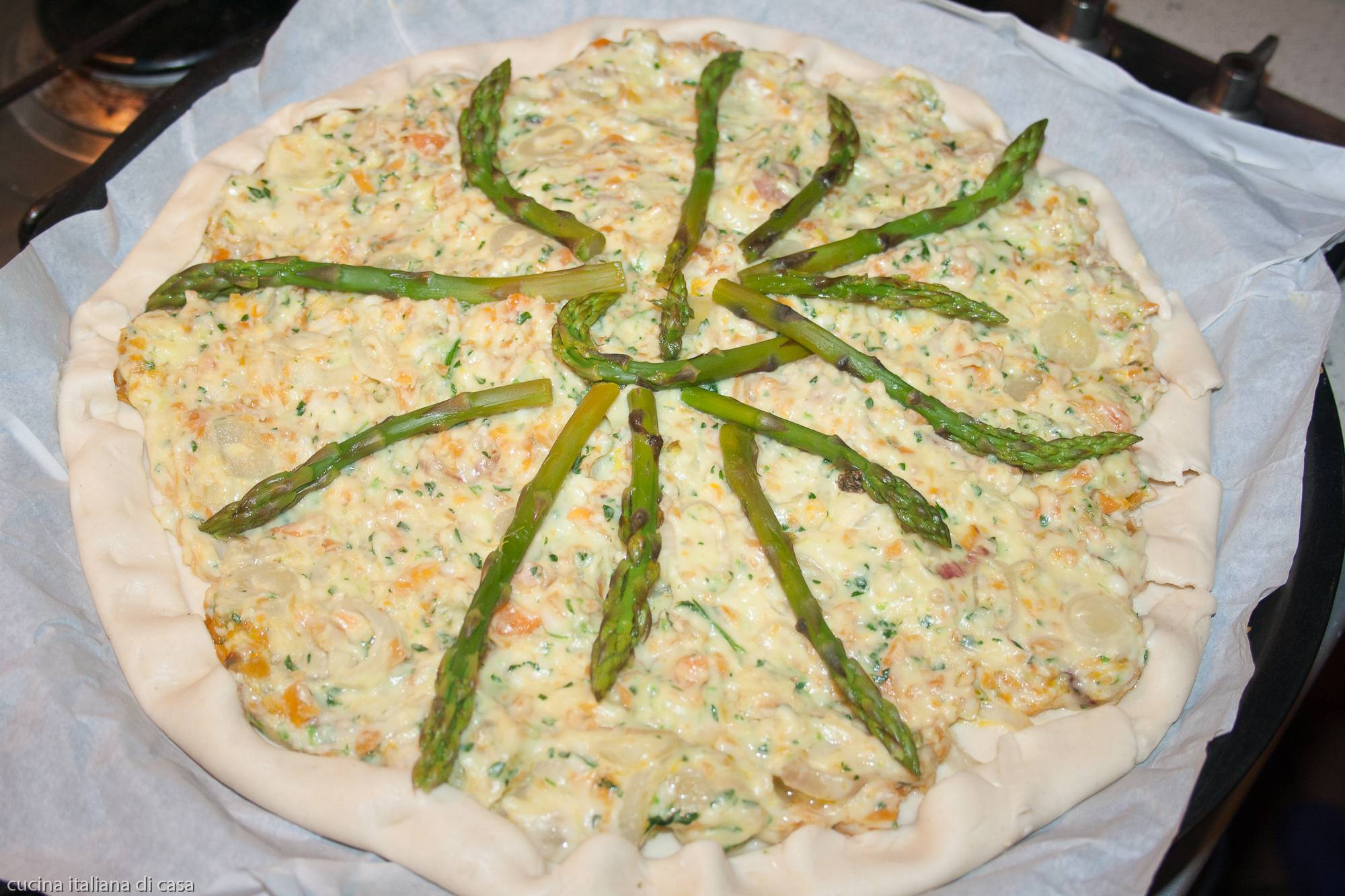 torta salata con bordi piegati e asparagi
