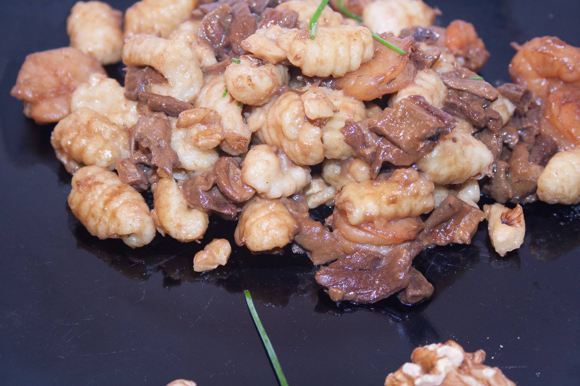 gnocchi con funghi su piatto nero