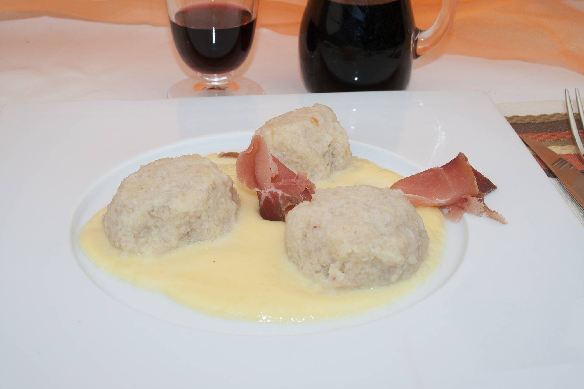 Canederli con fonduta di formaggio e speck, ricetta tradizionale con foto